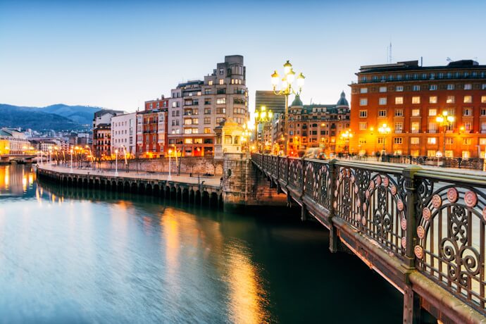 Evening lights shimmer over the Nervión River in Bilbao