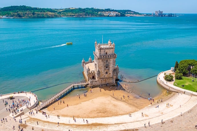 Belém Tower standing at the edge of the Tagus River.