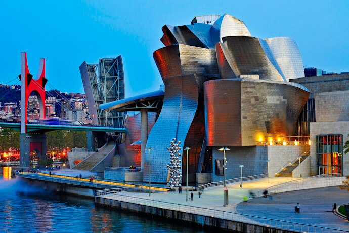 In Bilbao, the Guggenheim Museum stands out with its striking, metallic curves, set beside the river.
