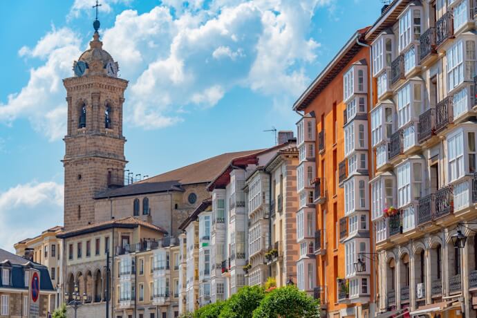 In Vitoria-Gasteiz, the Old Town reveals historic buildings and a church tower, with colorful façades lining the streets.