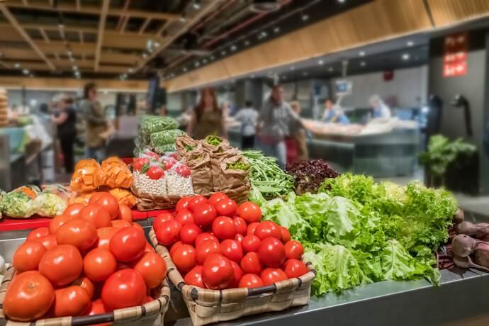 Fresh fruits and vegetables, including tomatoes, salad leaves, and beetroot on display at the San Martin Merkatua Market in San Sebastián.
