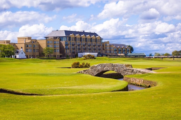 View of the Old Course at St Andrews with its famous stone bridge and a large hotel building in the background