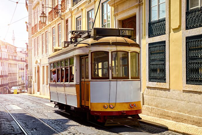 Yellow vintage train crossing the streets of Lisbon, Portugal