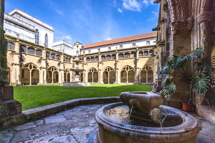 Gothic cloister of the Old Cathedral of Coimbra, with stone arches and a central courtyard, in Coimbra, Portugal.
