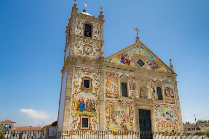 Colorful azulejo-covered facade of the Church of Santa Maria de Válega in Ovar, Portugal.