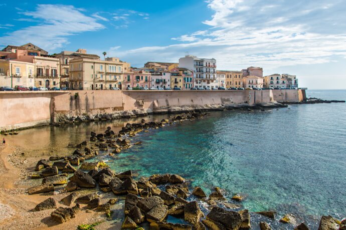 The historic seafront of Ortigia, with its ancient walls meeting the clear Ionian Sea