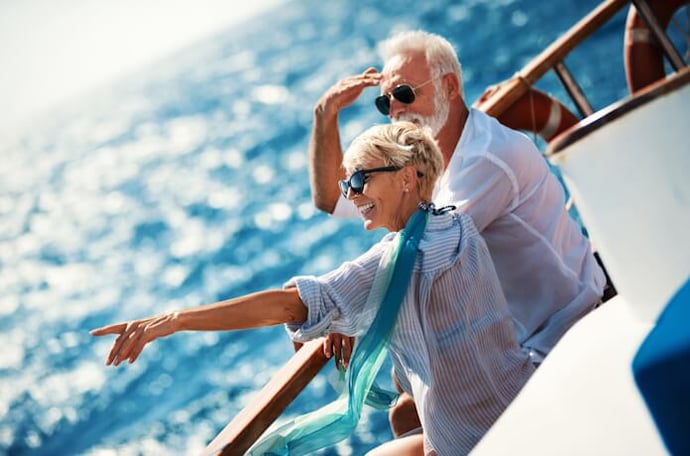 Smiling senior couple enjoying a sunny boat ride on the Mediterranean sea.
