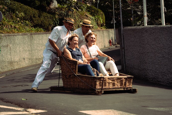 Two women enjoying Madeira’s traditional wicker toboggan ride