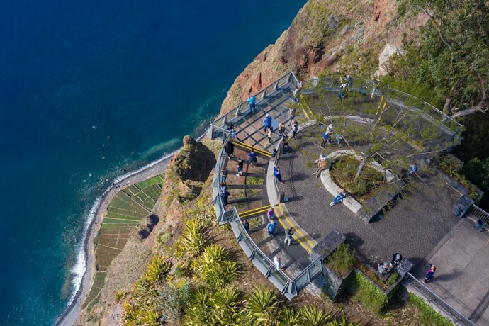 Tourists standing on glass skywalk overlooking Madeira's Cabo Girão