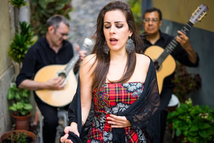 Traditional Fado performance in Lisbon, Portugal, with a singer and Portuguese guitar musicians