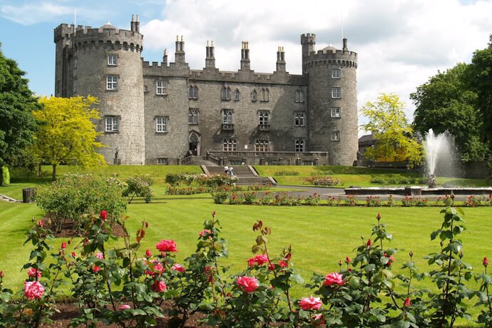 Kilkenny Castle surrounded by landscaped gardens and colorful flowers in Kilkenny.