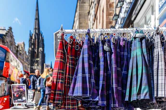 Colorful tartan kilts displayed outside a shop on Edinburgh's Royal Mile.