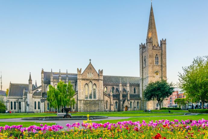 St. Patrick’s Cathedral in Dublin surrounded by green gardens and spring flowers, highlighting the city’s rich medieval heritage and elegant architecture.