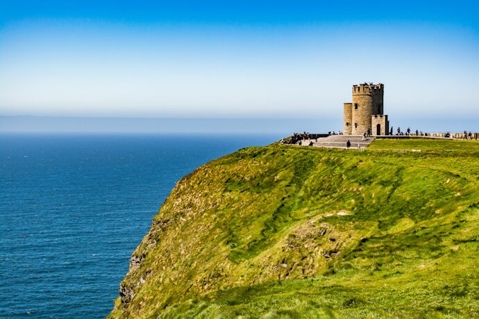 Stone watchtower perched on the dramatic Cliffs of Moher, overlooking the Atlantic Ocean and rolling green headlands along Ireland’s Wild Atlantic Way.