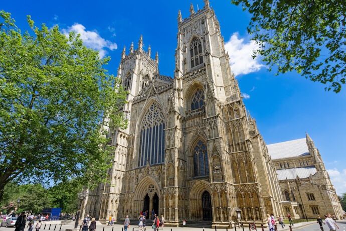 People exploring the timeless beauty of York Minster on a sunny day