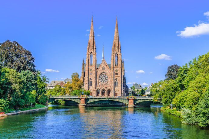Strasbourg Cathedral, a stunning example of Gothic architecture, stands tall with its intricate façade adorned with detailed sculptures and a towering spire.