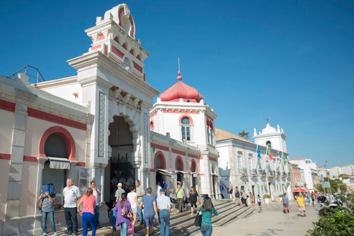People visiting the Moorish-style market building in Loulé, Algarve, on a sunny day.
