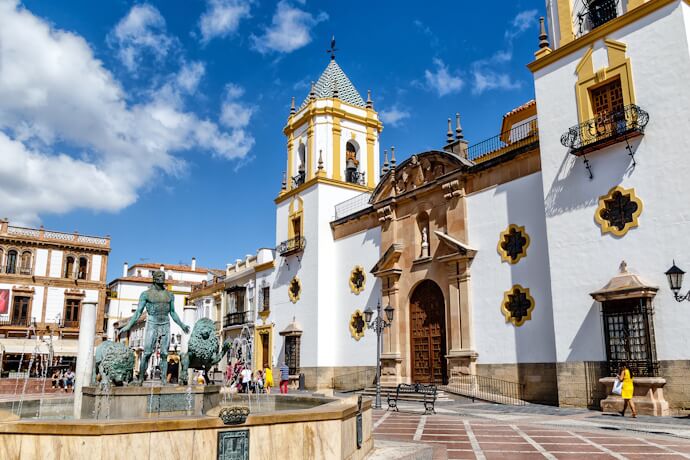 Historic town square in Ronda, Andalusia, with a church and fountain