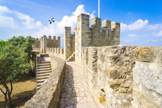 Stone walls and towers of São Jorge Castle offering sweeping views over Lisbon’s historic neighborhoods.