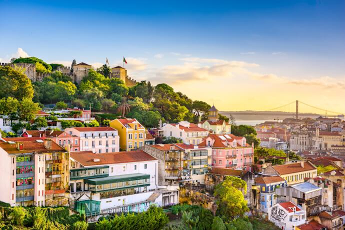 A panoramic view of the city of Lisbon, with the São Jorge castle of the left and the 25th April bridge on the right.