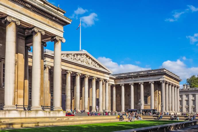 The British Museum in London with its grand neoclassical columns and visitors gathered outside.