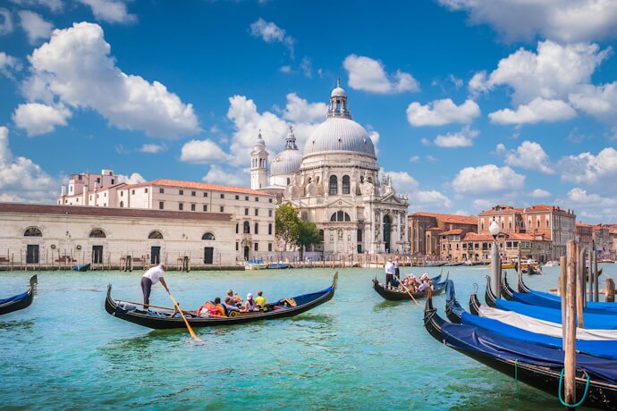Gondolas floating on the Grand Canal with Santa Maria della Salute basilica in Venice.