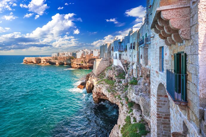 Cliffside houses in Polignano a Mare overlooking the turquoise Adriatic Sea, highlighting Puglia’s dramatic coastal scenery.
