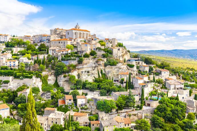 Hilltop village of Gordes in Provence, France, with stone houses cascading over rocky cliffs and views across the Luberon countryside