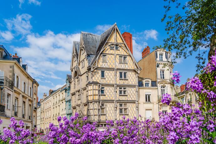 Maison d’Adam in Angers, Loire Valley, France, a historic half-timbered house surrounded by colorful flowers in the city center