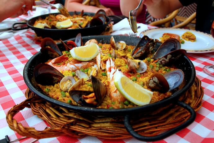 People trying the traditional seafood paella in Valencia, Spain