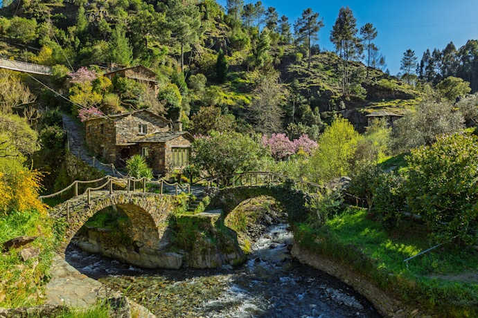 Stone bridge crossing the Piódão stream in the picturesque Schist Village of Piódão, Portugal.
