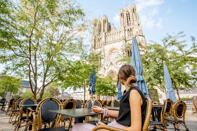 Girl at a café terrace near Reims Cathedral, in Reims, France