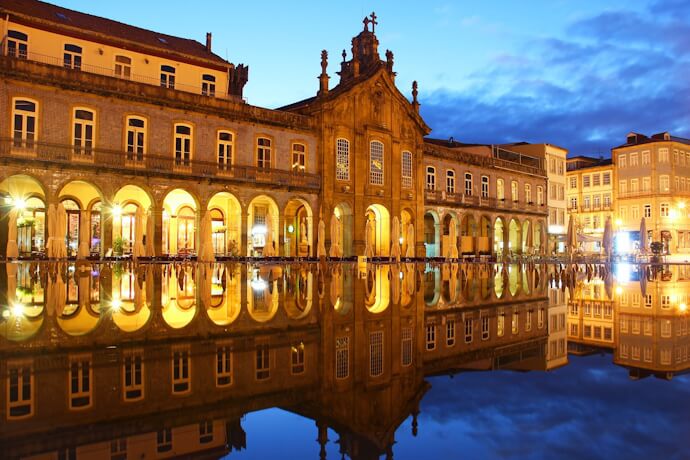 Evening lights glow in Praça da República, Braga, reflected on the square’s smooth surface.