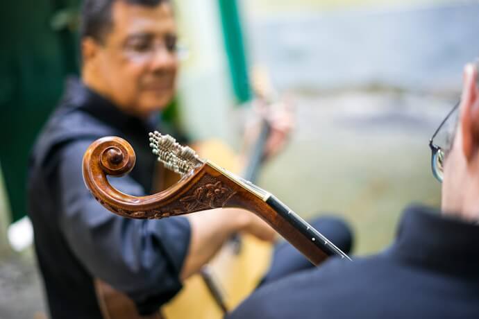 Musician playing Portuguese guitar during a Fado performance.