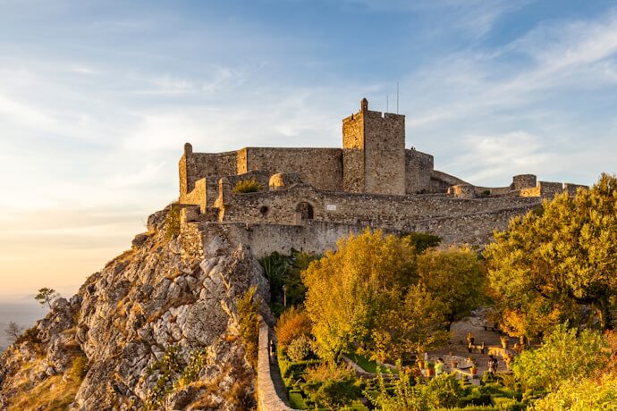 Stone castle on a hill surrounded by trees in Marvão, Portugal.