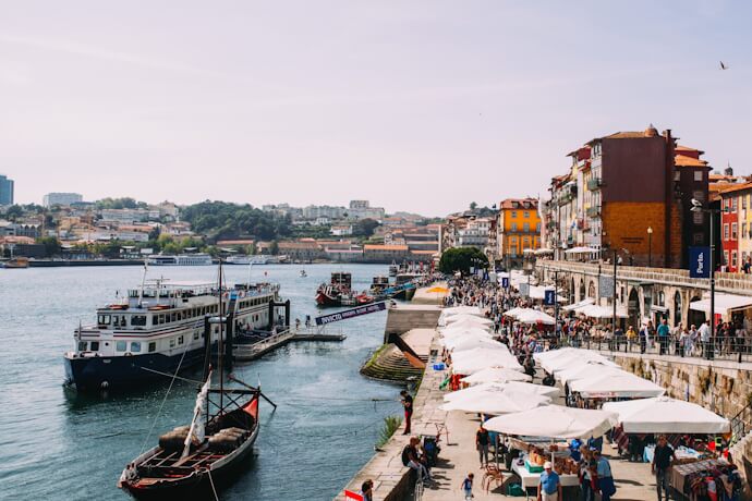 Boats and people along the Ribeira waterfront in Porto, Portugal.