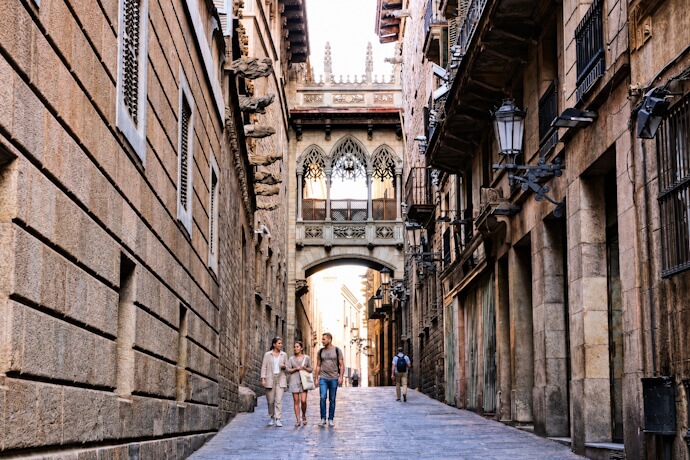 Historic street in Barcelona's Gothic Quarter, with the famous Pont del Bisbe overhead.