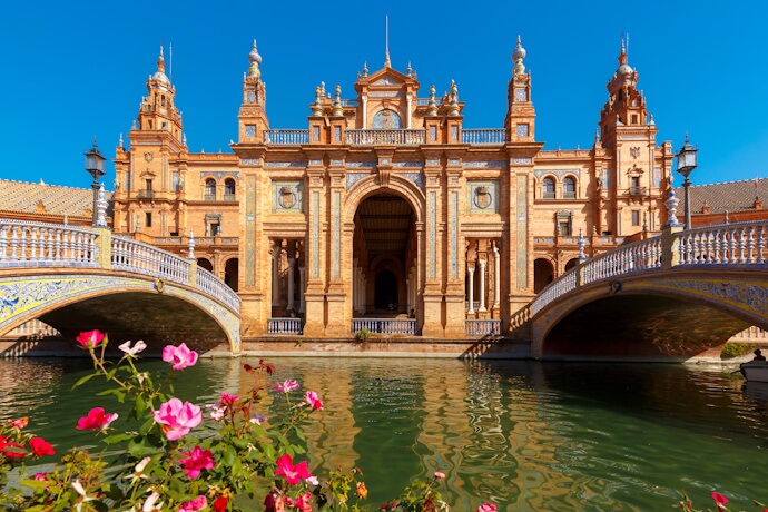 Seville Plaza de España with ornate bridge and canal, vibrant spring travel destination in southern Spain