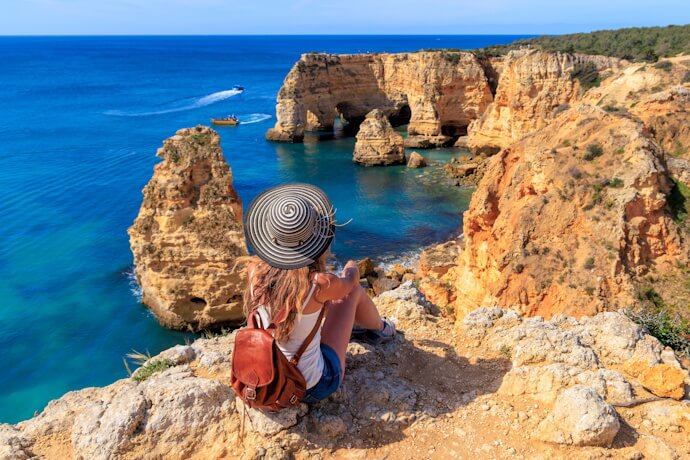 Algarve coastline with dramatic golden cliffs and turquoise sea, summer beach travel in Portugal