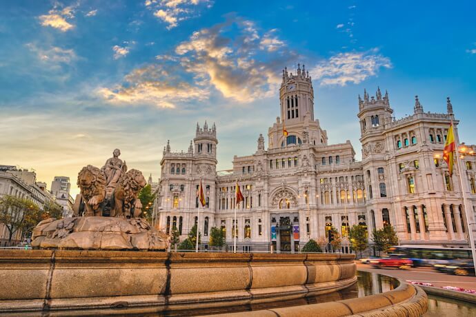 Madrid Plaza de Cibeles fountain with grand historic architecture at sunset, iconic city landmark in Spain