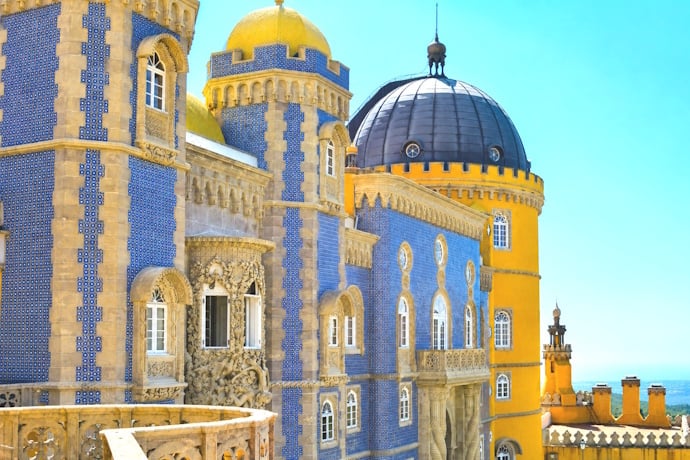 Colorful towers and ornate details of Pena Palace rising above the hills of Sintra.