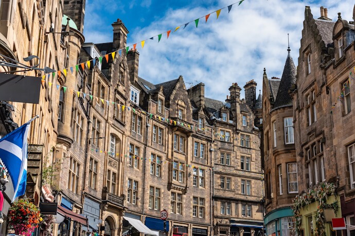 Historic stone buildings along a decorated street in Edinburgh.