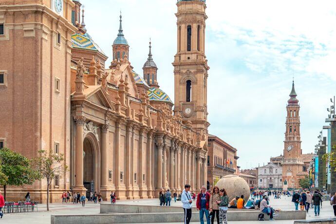 People in a square in front of the Basilica del Pilar in Zaragoza, Spain