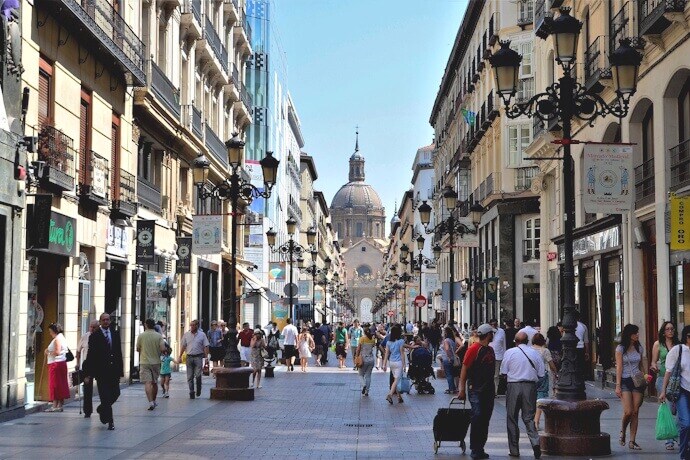 People in a street in Zaragoza with view of the Basilica