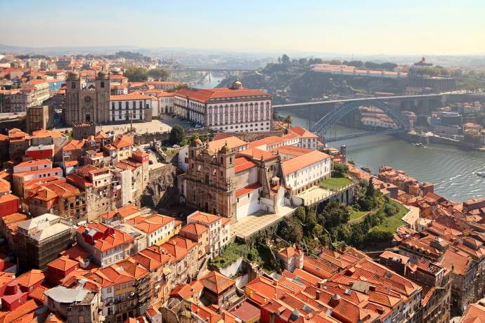 Panoramic view of Porto, Portugal, with terracotta rooftops, historic churches, the Douro River, and Dom Luis I Bridge