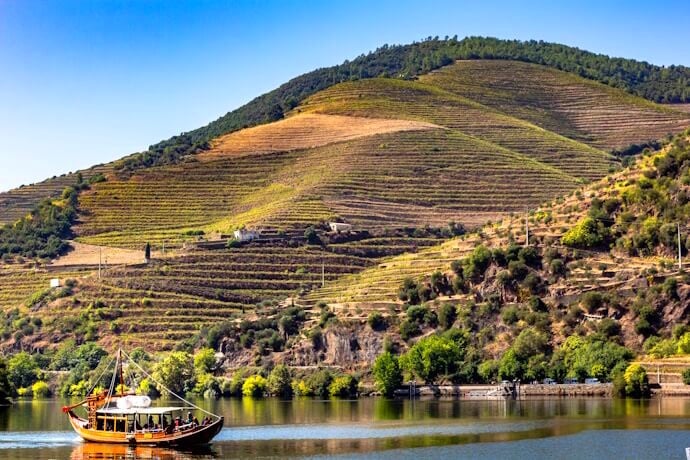 Boat crossing the Douro River with view of the vineyards