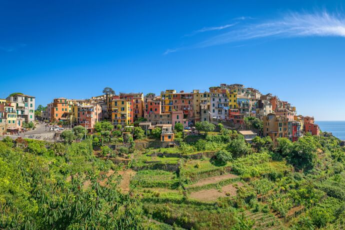A hilltop village in Corniglia surrounded by vineyards, featuring colorful houses overlooking the Mediterranean.