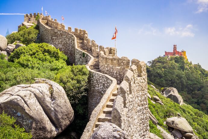 Moorish Castle walls overlooking the hills of Sintra with Pena Palace in the distance