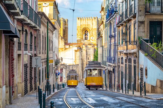 Historic yellow tram climbing one of Lisbon’s steep streets.