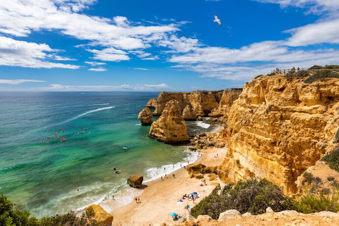 Golden limestone cliffs and turquoise waters along the Algarve coast.